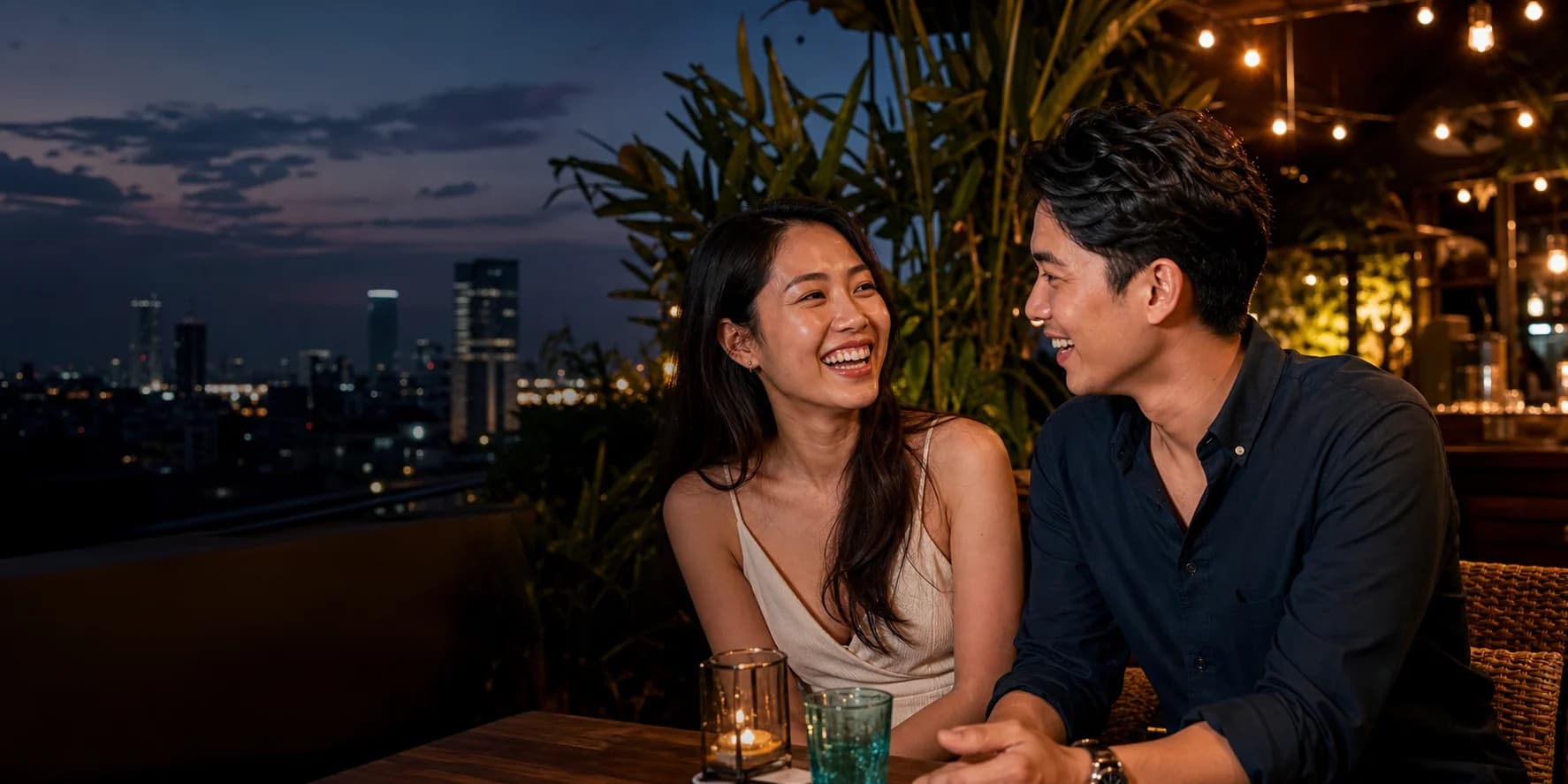 Two adults enjoying a relaxed first-date conversation on a Bangkok terrace